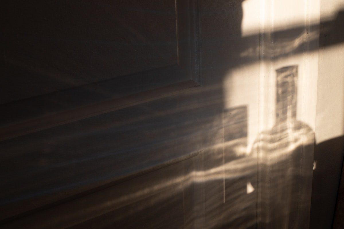 glass bottle reflection against a white wall